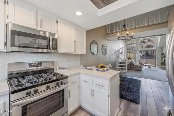 a kitchen with cabinets and wooden floor