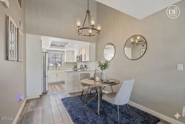 a dining room with wooden floor a glass table and chairs
