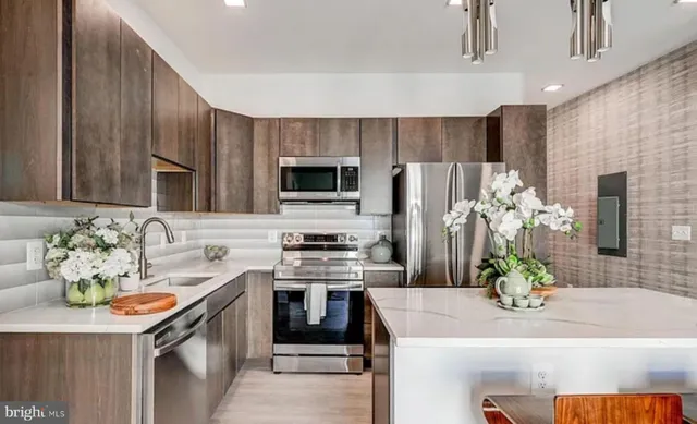a kitchen with stainless steel appliances a sink stove and refrigerator