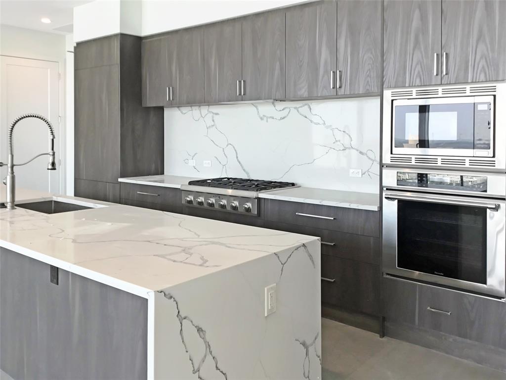 2120 Olive Street, Unit 3303 Dallas, TX 75201 - Photo 1 of 1 a kitchen with granite countertop a stove and a microwave