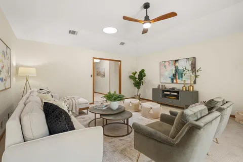 a living room with furniture and a chandelier