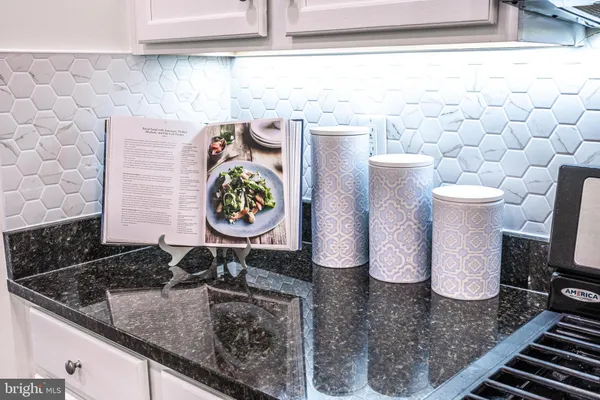 a bathroom with a granite countertop sink and a white stove