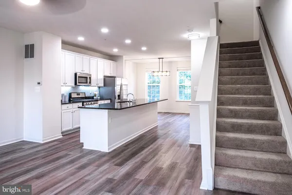 a view of kitchen with sink and refrigerator
