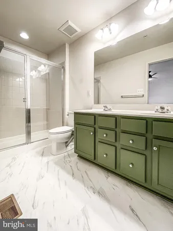 a bathroom with a double vanity sink mirror and toilet