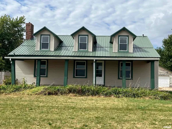 a view of a brick house with large windows and a yard