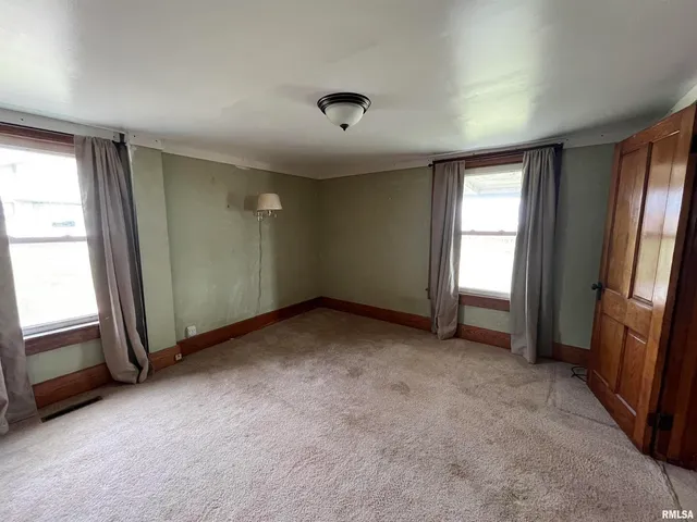 an empty room with windows and cabinet