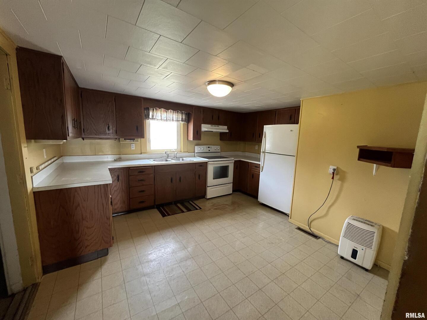 2283 East 2750th Street Kewanee, IL 61443 - Photo 20 of 58 a kitchen with a sink a stove a refrigerator and cabinets