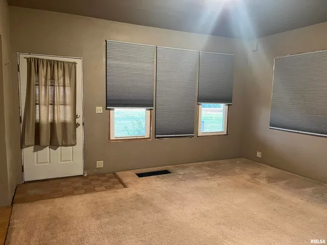 an empty room with windows and closet