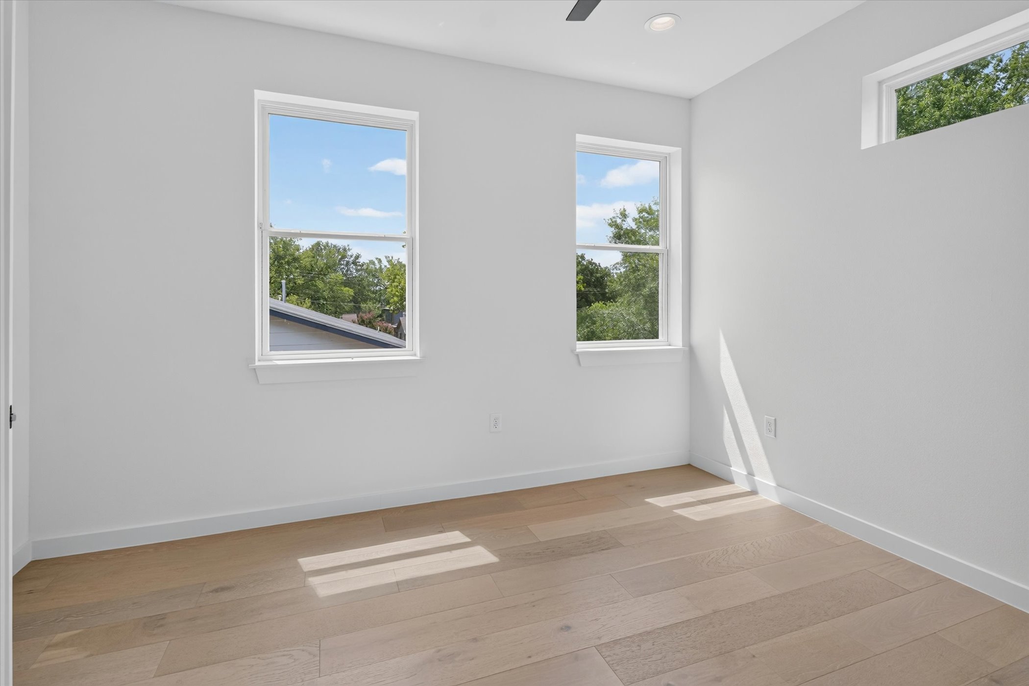 5305 Ledesma Road, Unit 1 Austin, TX 78721 - Photo 22 of 29 Blonde wood flooring and multiple windows enhance this naturally illuminated bedroom.