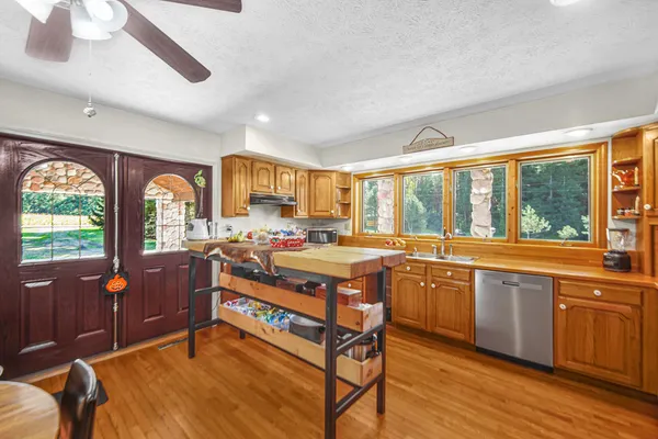a living room with stainless steel appliances granite countertop furniture a fireplace and a large window