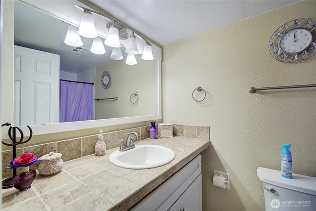 a bathroom with a granite countertop sink a large mirror and vanity