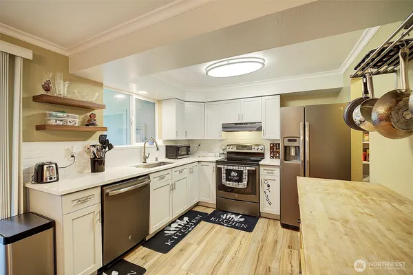 a kitchen with a sink appliances and cabinets