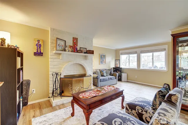 a living room with furniture a fireplace and a window