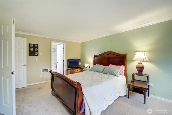 a bedroom with a bed and a lamp on table