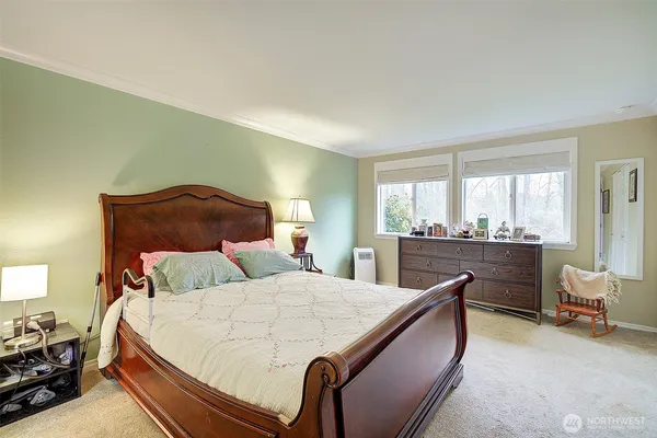 a bedroom with a bed and a large window