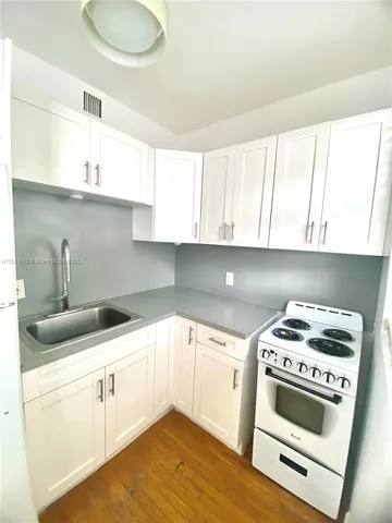 a kitchen with a sink a stove and cabinets
