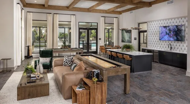 a living room with furniture a large window and potted plants