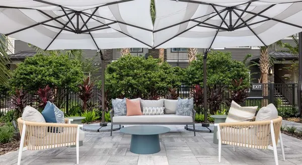 a view of a patio with a table and chairs under an umbrella