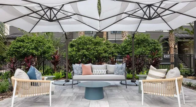 a view of a patio with a table and chairs under an umbrella