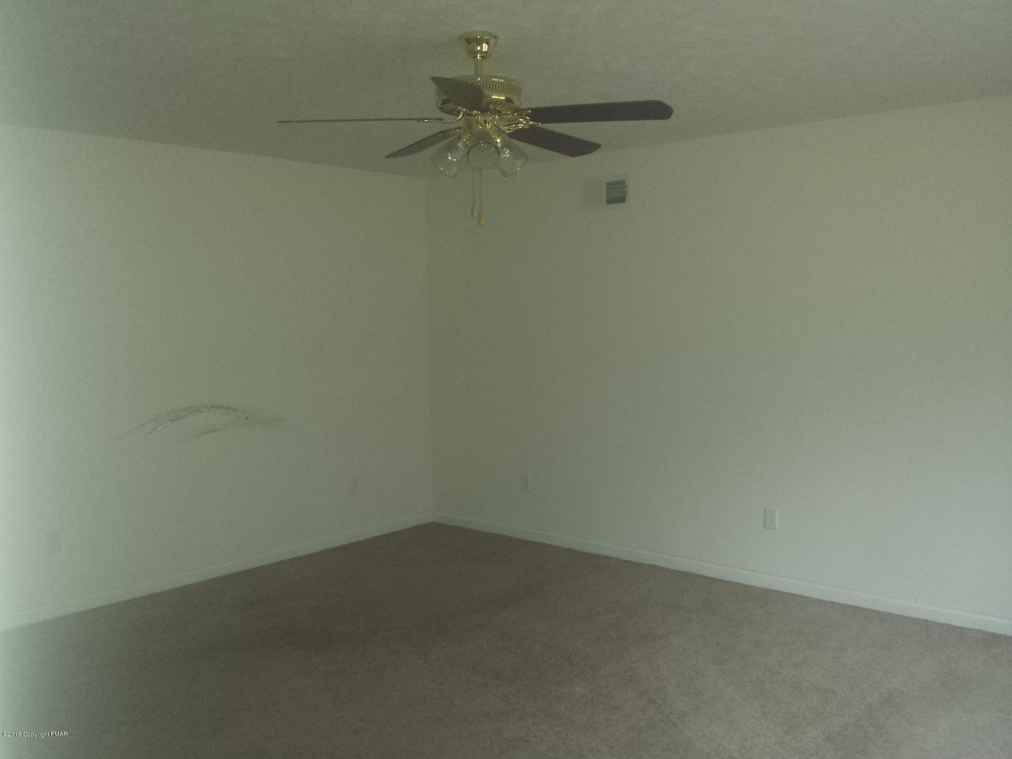 276 Powder Horn Road Henryville, PA 18332 - Photo 7 of 16 an empty room with a ceiling fan and carpet