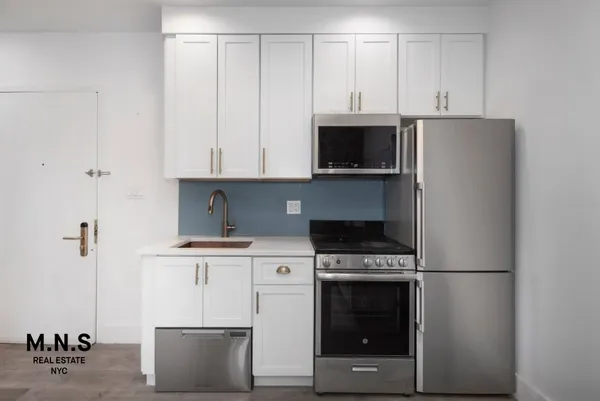 a kitchen with cabinets stainless steel appliances and a sink