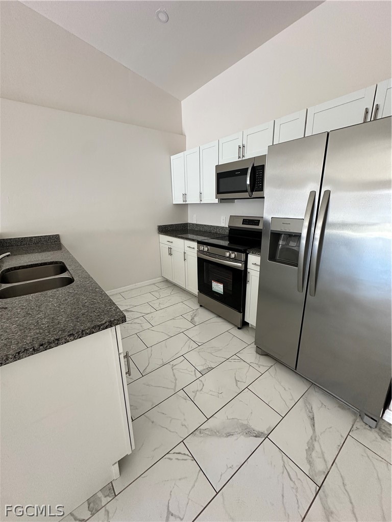 252 Southwest 3rd Street Cape Coral, FL 33991 - Photo 3 of 16 a kitchen with stainless steel appliances granite countertop a refrigerator sink and stove