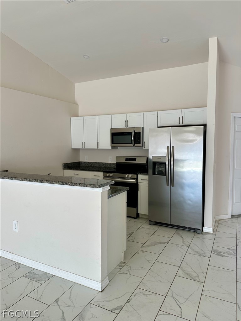 252 Southwest 3rd Street Cape Coral, FL 33991 - Photo 6 of 16 a kitchen with cabinets and stainless steel appliances