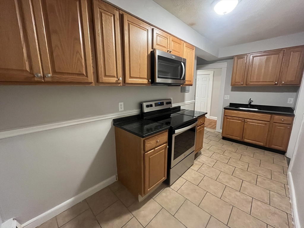 a kitchen with stainless steel appliances granite countertop a stove a sink and a microwave