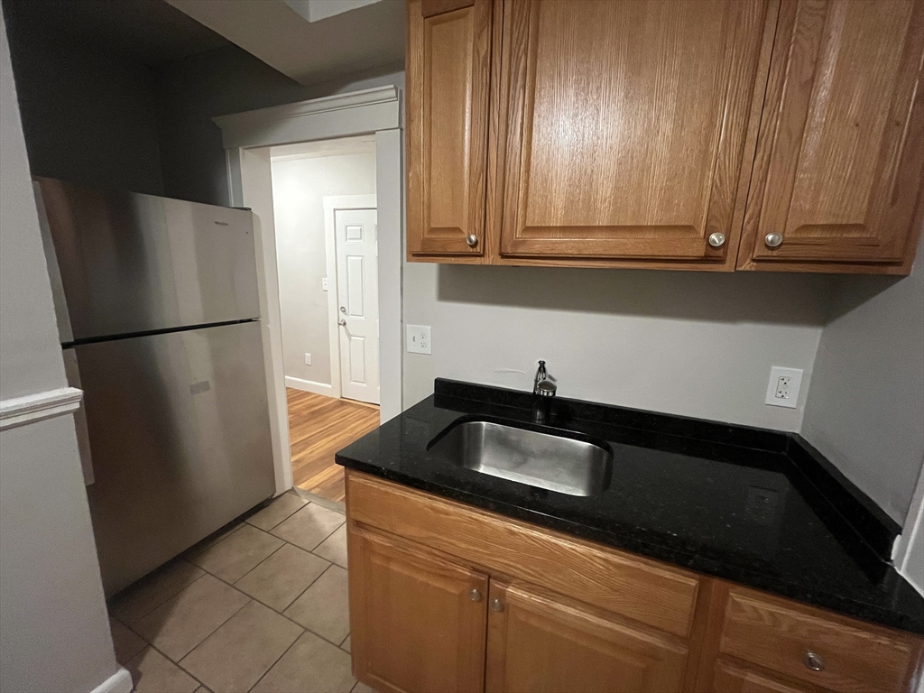77 Green Street, Unit 24 Lynn, MA 01902 - Photo 2 of 5 a kitchen with a refrigerator and a sink