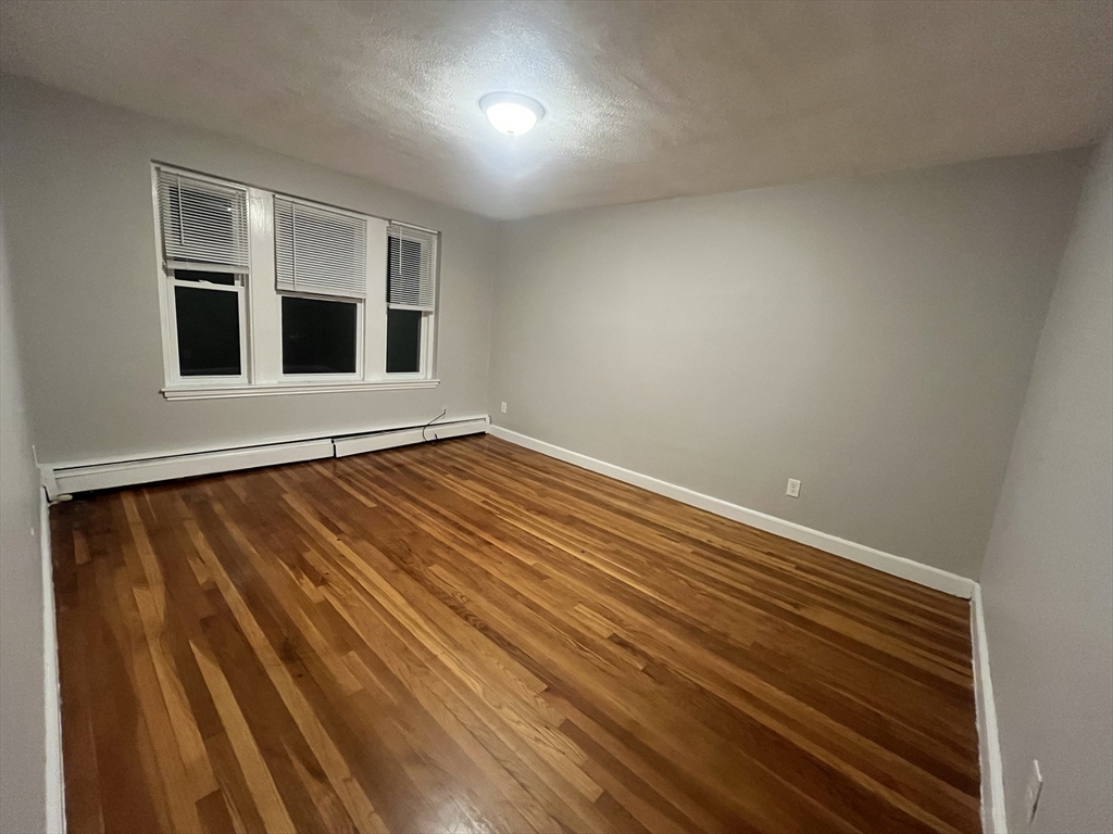 77 Green Street, Unit 24 Lynn, MA 01902 - Photo 3 of 5 a view of an empty room with wooden floor and a window