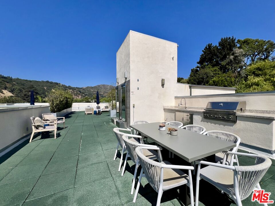 11715 Bellagio Road, Unit 204 Los Angeles, CA 90049 - Photo 23 of 27 a balcony with table and chairs