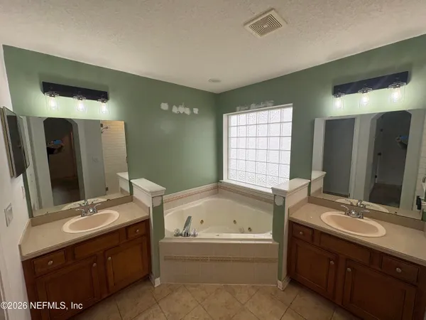 a bathroom with a tub sink and mirror
