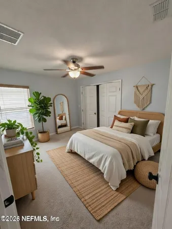 a bedroom with a bed mirror and window