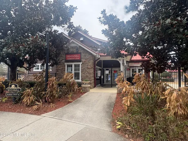 a view of a house with a tree in front of it