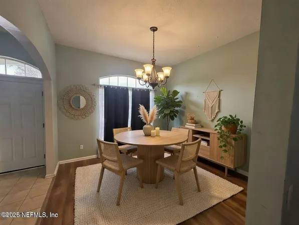 a dining room with furniture potted plants and wooden floor