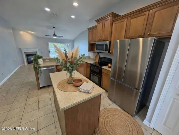 a kitchen with stainless steel appliances a refrigerator sink and microwave