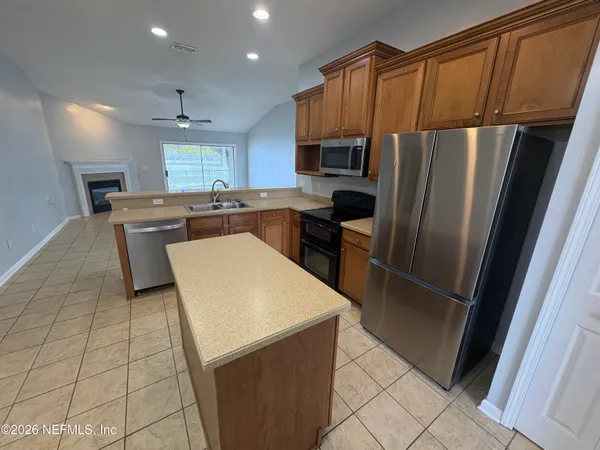 a kitchen with stainless steel appliances a refrigerator sink and microwave