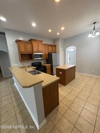 a kitchen with kitchen island granite countertop wooden cabinets a sink and a counter top space