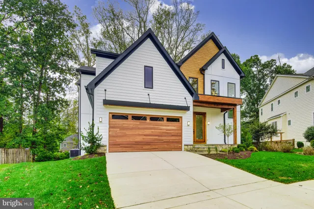 a large kitchen with stainless steel appliances kitchen island granite countertop a large kitchen island a stove a sink a refrigerator white cabinets and couches with wooden floor