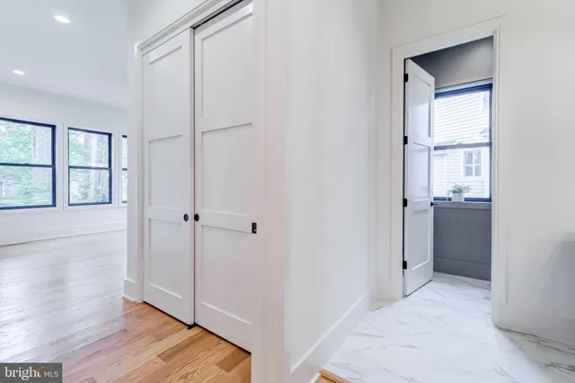 a view of an empty room with a window and a kitchen