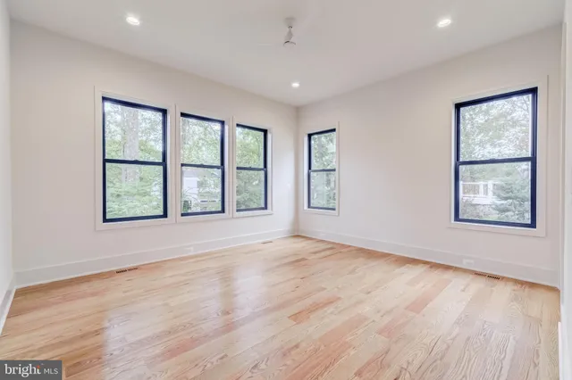 a view of empty room with wooden floor and windows
