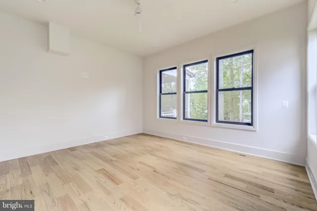 a kitchen with a sink and a stove with wooden floor