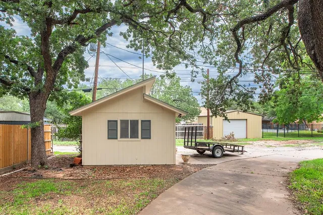 a view of a house with a yard and large tree