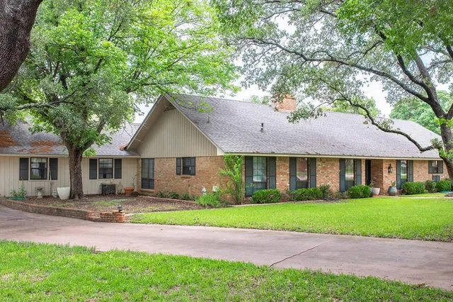 a front view of a house with a yard and trees
