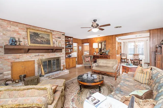 a living room with fireplace furniture and a large window
