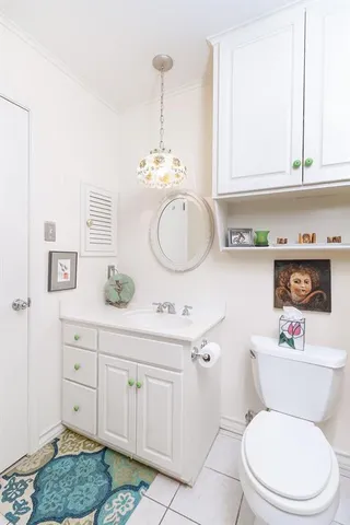 a bathroom with a toilet sink vanity granite and mirror