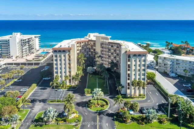 a front view of multi story residential apartment building with yard and sign board