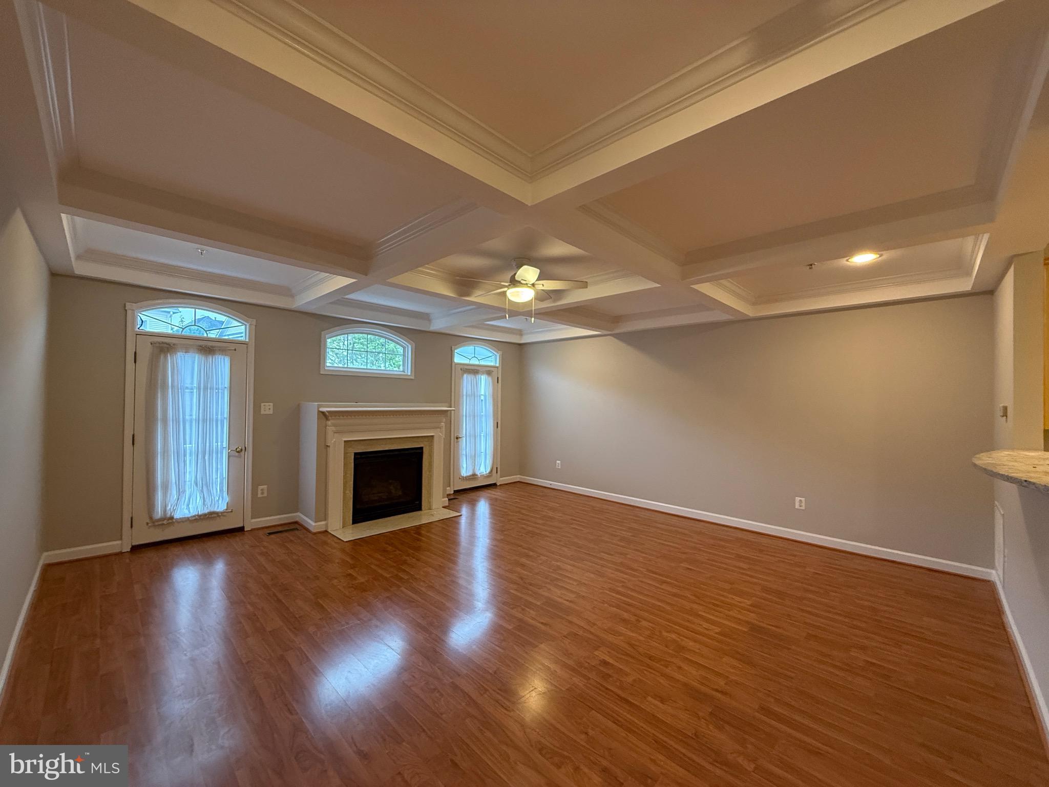 1127 Gaither Road Rockville, MD 20850 - Photo 12 of 26 a view of a livingroom with wooden floor a fireplace and window