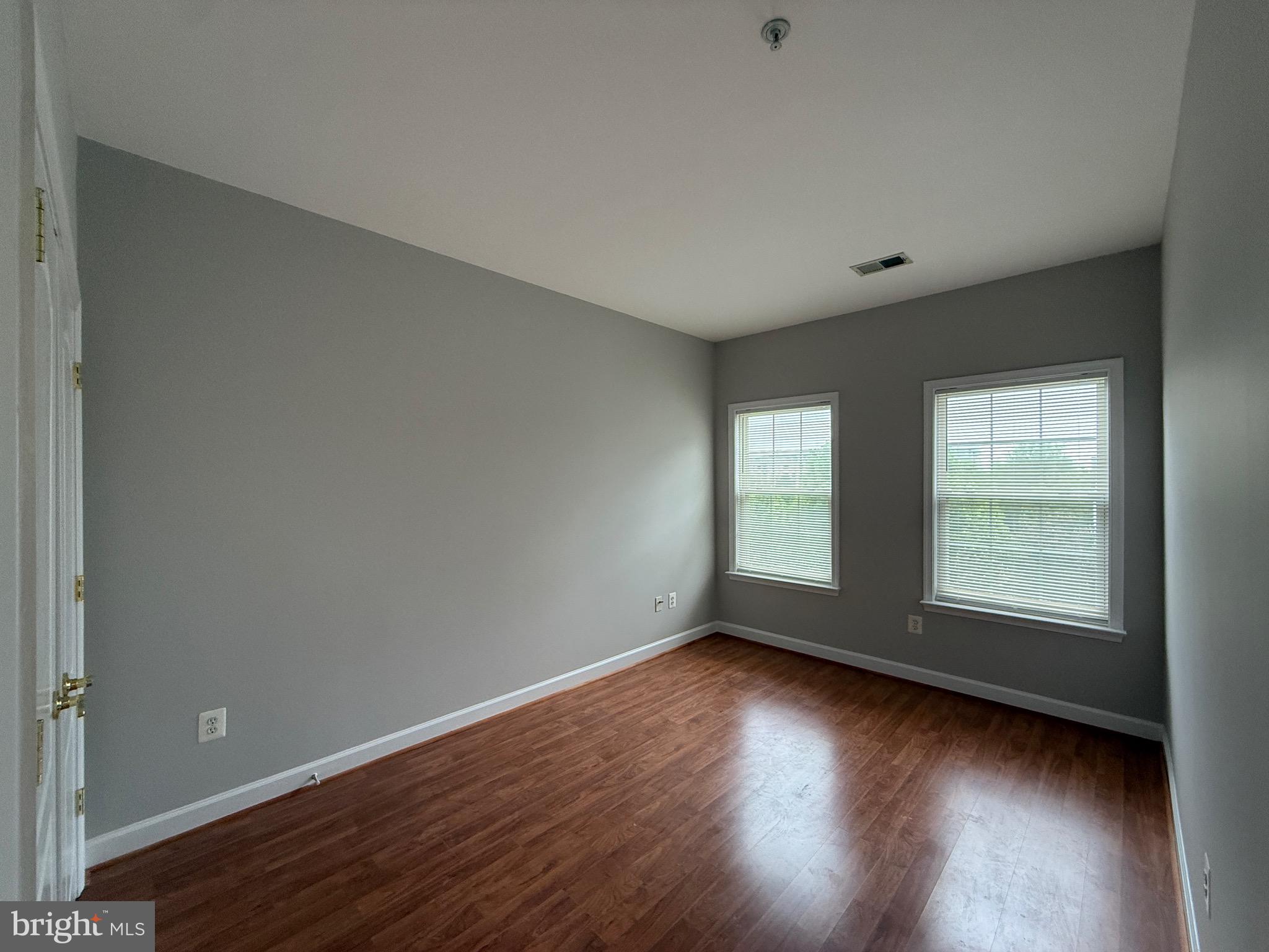 1127 Gaither Road Rockville, MD 20850 - Photo 24 of 26 an empty room with wooden floor and windows