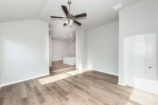 a view of a big room with wooden floor and a ceiling fan